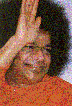 Sathya Sai Baba close up, face and shoulder, hand held high